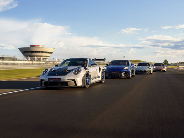 Ein Gruppen von Porsche Fahrzeugen auf der Rundstrecke des Porsche Experience Center Leipzig.