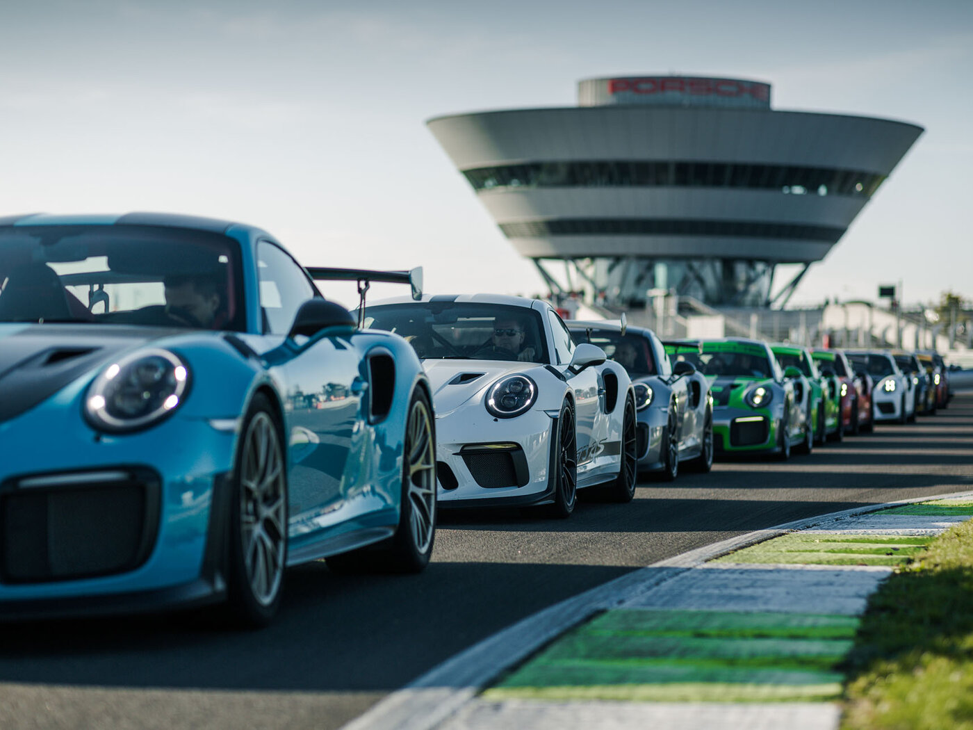 Meine Fahrzeuge stehen auf der Rennstrecke des Porsche experience Center Leipzig im Hintergrund ist das experience Center zu erkennen