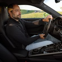 Mann fährt Porsche.