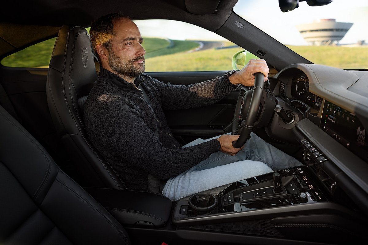 Mann fährt Porsche.