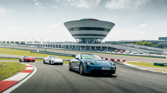 Three Porsche 911s drive one after the other around the circuit.