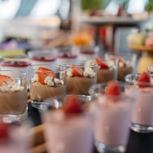 Erdbeerjoghurt und Schokoladenmousse mit frischen Früchten in kleinen Gläsern