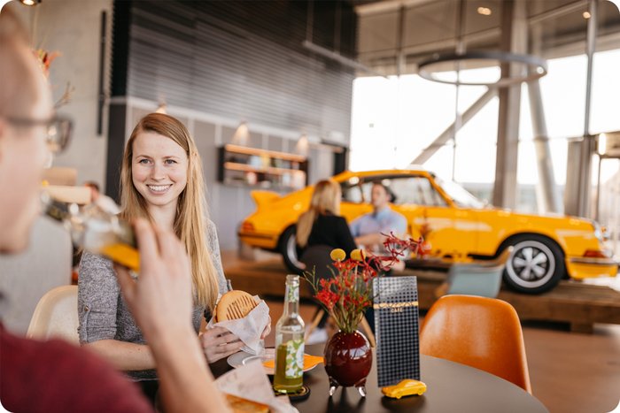 Mehrere Personen setzen im Carrera Café, essen und trinken