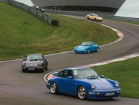 Porsche Oldtimer fahren auf der Rundstrecke.