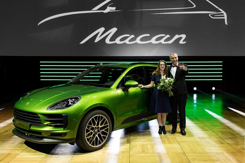 Die Tombolagewinner sind mit dem Hauptgewinn, ein Macan zu sehen. 