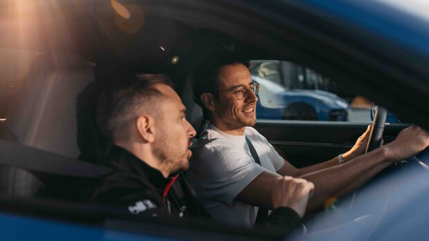 Instrukteur weißt Mann im Fahrzeug ein und erklärt alles rund um das Auto.