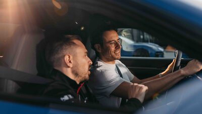 Instrukteur weißt Mann im Fahrzeug ein und erklärt alles rund um das Auto.