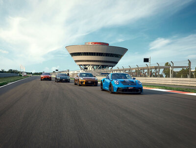 Eine Gruppe von Porsche Sportwagen auf der Rennstrecke des Porsche experience Center, Leipzig