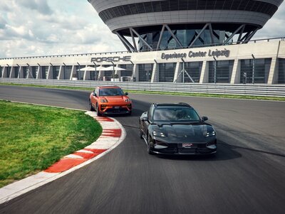 Eine Gruppe von Porsche Fahrzeugen auf der Rennstrecke des Porsche experience Center, Leipzig