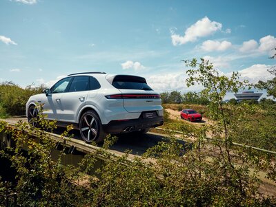 Ein Porsche Cayenne im offroad Gelände bei der Überfahrt über eine Brücke