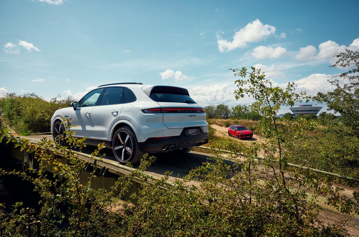 Ein Porsche Cayenne im Gelände bei der Überfahrt über eine Brücke