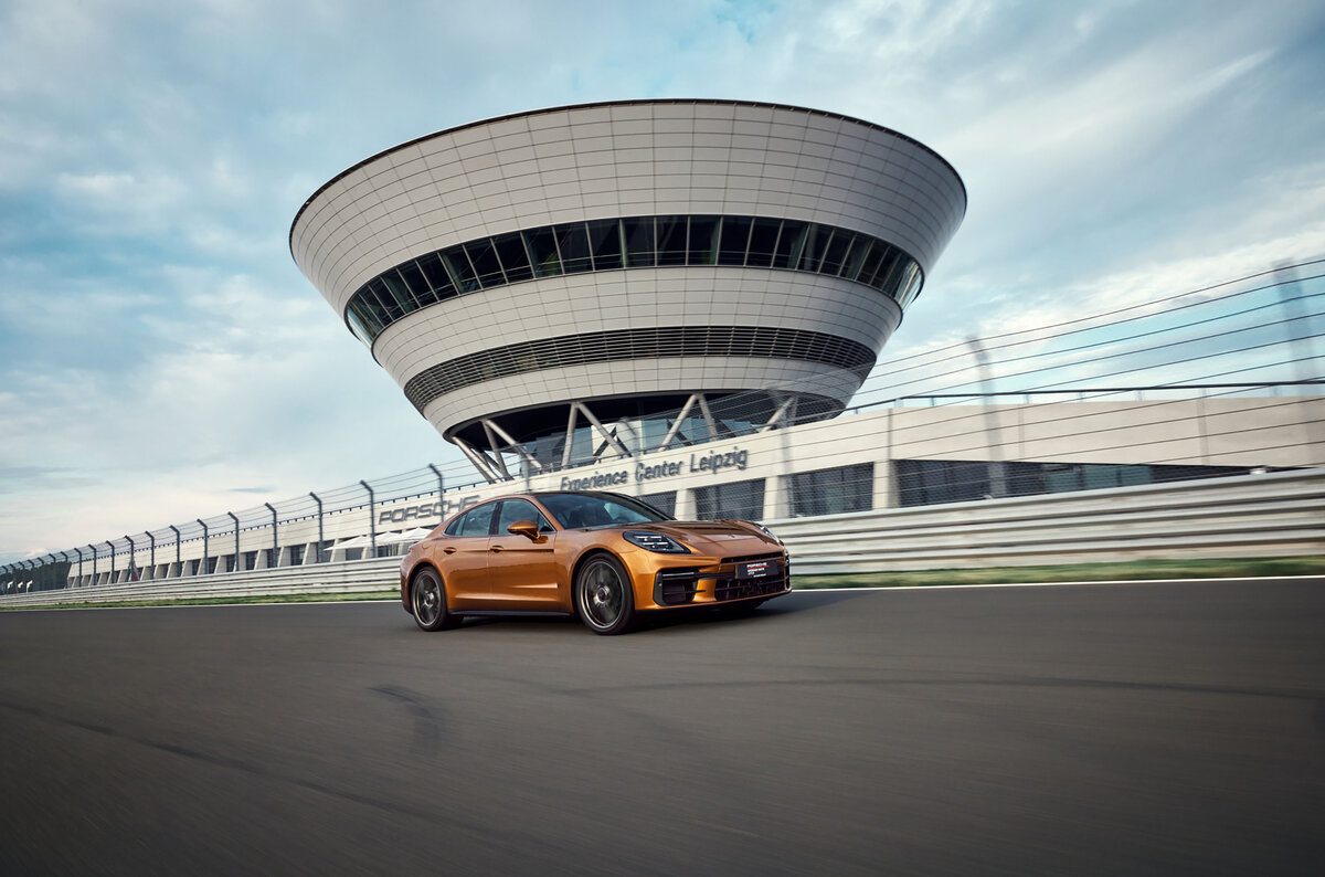 Ein Porsche Panamera auf der Rheinstrecke und im Hintergrund das Porsche experience Center