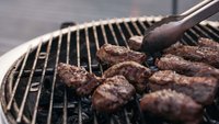 Ein Grill in Nahaufnahme ist zu sehen. Es wird hochwerties Fleisch gegrillt.