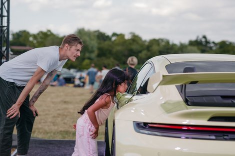 Tochter und Vater schauen sich die Autoausstellung an