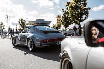 Zwei klassische Porsche Fahrzeuge fahren auf dem Parkplatz des Porsche experience Center, Leipzig