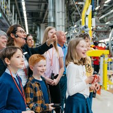 Die Werksführerin erklärt einen Produktionsschritt der Familie. Alle schauen gespannt zu was in der Produktion passiert.