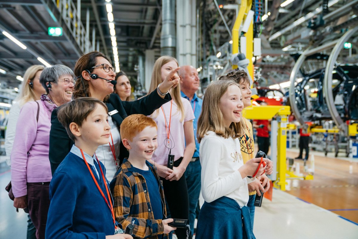 Die Werksführerin erklärt einen Produktionsschritt der Familie. Alle schauen gespannt zu was in der Produktion passiert.