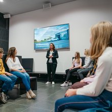 Die Familie sitzt im Begrüßungsraum und bekommt eine Einleitung von der Werksführerin präsentiert.