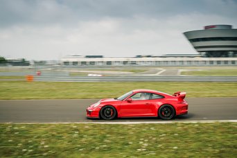 Ein roter Porsche neun elf GT drei auf der Rennstrecke des Porsche experience Center Leipzig